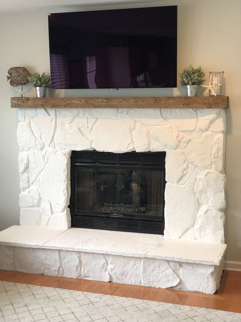 Outdated Grey stone fireplace painted white! Also a change to the mantel to natural stained wood Painted White Rock Fireplace, Painted Cobblestone Fireplace, Natural Stone Fireplaces Modern, Stone Fireplace Painted White, Painted White Stone Fireplace, Painting Stone Fireplace White, Shiplap Over Stone Fireplace, White Washing Stone Fireplace, White Stone Fireplace With Wood Mantel