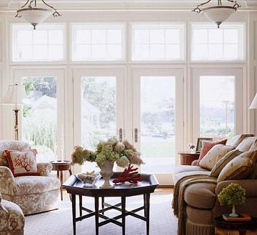 Some well-matched windows and doors do right by this room's traditional architecture. A pair of French doors is flanked by equally sized windows. Large transoms match the size of the windows and doors below, creating a floor-to-ceiling wall of light. Beautiful trim painted in crisp white ties the whole wall together. French Doors Living Room, Exterior French Doors, White Ties, French Doors Exterior, French Country Living Room, French Doors Patio, Country Living Room, Living Room Windows, French Doors Interior