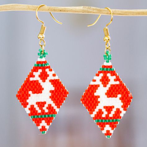 A palette of red and green tones evokes one of the cutest Christmas creatures. Handcrafted in Mexico by Diana Padilla, these diamond-shaped dangle earrings feature a glass beaded design depicting two adorable reindeer. On top of that, the accessories come with 18k gold-plated hooks that allow you to wear them in all their beauty. Xmas Beads, Green And Red Christmas, Christmas Jewelry Diy, Holiday Beading, Earrings Patterns, Seed Beading, Seed Bead Patterns, Christmas Bead, Beaded Earrings Patterns