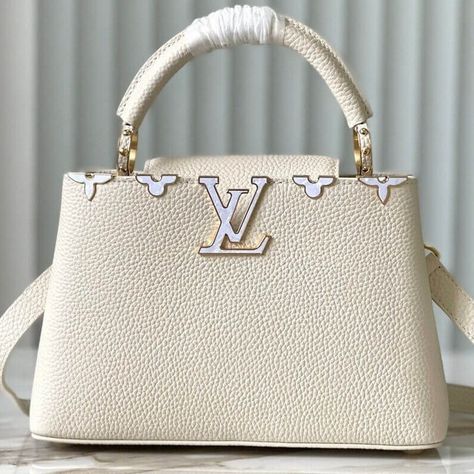 Fashioned from full-grain Taurillon leather, this Capucines BB Flower Crown handbag is adorned with decorative Monogram Flowers, each one crafted from delicate mother of pearl. The LV signature, echoing the flower, adds another jewel-like touch to this ultra-feminine accessory. With its detachable strap, the bag may be styled for shoulder or cross-body wear. Taurillon leather Taurillon-leather trim Cowhide-leather lining Mother-of-pearl and gold-color hardware Double carry style: flap inside ... Louis Vuitton Capucines Bb, Louis Vuitton Capucines, Ultra Feminine, Flower Crown, Leather Trim, Cowhide Leather, Leather Trims, Cross Body, Mother Of Pearl