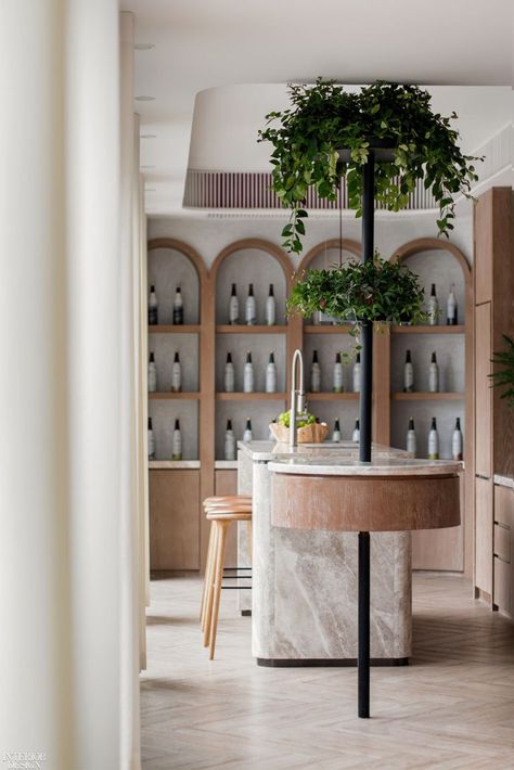 Red wine bottles are displayed in balance with specially formulated enzyme beverages in the arch-shaped oak feature wall. The narrow space challenged founder and principal of M.R. Studio Myron Kwan to think outside the box for how best to display products. #Arch #InteriorDesign #Marble R Studio, Calming Spaces, 타이포그래피 포스터 디자인, Balance Design, Big Design, Retail Interior, M R, Balanced Lifestyle, Commercial Interior Design