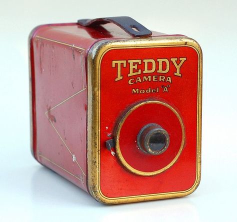 The Teddy Camera is a stamped-metal box camera, made c.1924 by the Teddy Camera Company of Newark, NJ. The camera came with a set of sensitized cards, and made 2" x 3½" prints, developed on-the-spot within a tubular developing tank which attached to the bottom. From John Kratz. Antique Cameras, Pinhole Camera, Newark Nj, Box Camera, Camera Obscura, Old Cameras, Classic Camera, Film Photography 35mm, Jukeboxes