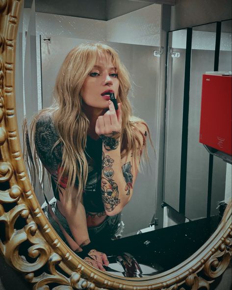 Blonde hair girl looking into mirror putting lipstick on like the bad b she is Blonde Rockstar Aesthetic, Blonde Rockstar Hair, Cans In Hair Photoshoot, Healer Branding Photoshoot, Tattoo Poses For Women, Blonde Edgy Girl, Witchy Blonde Hair, Female Tattoo Artist Photoshoot, Blonde Hair Photoshoot Ideas