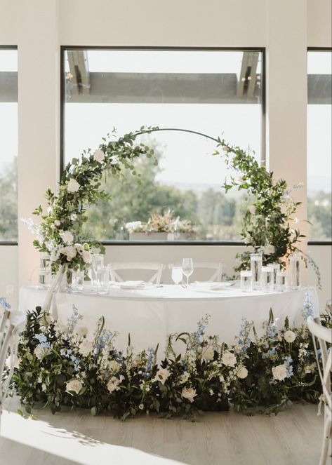 Gorgeous wedding sweetheart table inspiration for a light blue and white wedding palette. Serpentine table with floating candels and wildflower style arrangements. Floral design by @simplypetalsflowers🤍 Blue And White Sweetheart Table, Serpentine Tables Wedding, Main Table Wedding Decoration, White Wedding Palette, Light Blue And White Wedding, White Sweetheart Table, Serpentine Table, Sweetheart Table Centerpiece, Wedding Sweetheart Table