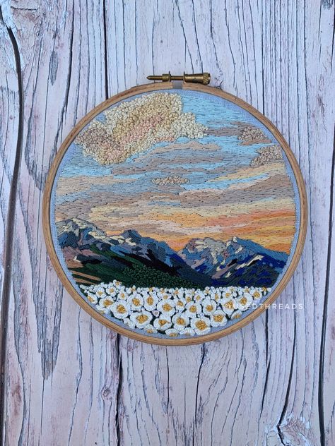 "6\" embroidery on blue linen. Thread painted mountain scene with a soft beautiful sunrise, dark mountain scape and quirky 3D floral field." Embroidered Mountain Scene, Knitted Landscape, Mountain Embroidery Pattern, Embroidered Mountains, Mountain Scape, Floral Field, Dark Mountains, Painting Pastel, Sunrise Landscape