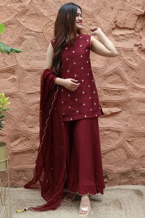 Sway away everyone with your simplicity as you wear this burgundy maroon silk sharara suit which will be scene-stealing ethnic wear to shine in the spotlight.This round neck and sleeveless party wear suit elaborated using thread work.Completed with silk sharara pants in burgundy maroon color with burgundy maroon organza dupatta.Sharara pants is plain.Dupatta designed using stonework.This sharara suit can be customised up to maximum size available in inches 58. Slight color variation may occur du Maroon Suit, Gaun Fashion, Stylish Short Dresses, Pakistani Fancy Dresses, Pakistani Dresses Casual, Pakistani Fashion Party Wear, Beautiful Pakistani Dresses, Sharara Suit, Salwar Kamiz