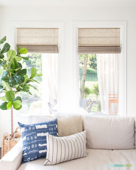 Natural woven roman shades in a living room with blue, white and green accents. Love the faux fiddle leaf fig tree! #home #homedecorideas #homedecor #livingroomdecor #livingroom #homeimprovement #fireplace Roman Shade Dining Room, Living Room With Roman Shades, Roman Shades In Living Room, Dining Room Roman Shades, Roman Shades Dining Room, Shades In Living Room, Living Room Roman Shades, Mango Ideas, Calm House