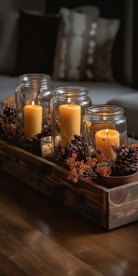 A beautiful rustic centerpiece featuring a variety of amber jar scented candles, pinecones, and dried flowers, arranged on a wooden tray.

Picture 3: Coffee Tray Decor Ideas, Dining Room Candle Centerpiece, Popurri Decor, Amber Glass Christmas Decor, Aesthetic Dining Table Decor, Christmas Living Room Decor Small Spaces, Candle Glass Jar Ideas, Tray Centerpiece Ideas, Winter Table Centerpieces