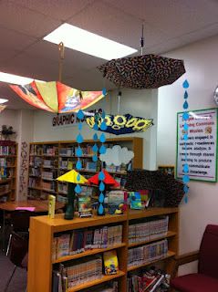 Like the idea of hanging umbrellas...would do them the right way down though. Library Decor Ideas, School Library Themes, Spring Library, Shelter From The Storm, Library Signage, School Library Displays, Teen Library, Future Library, Library Themes