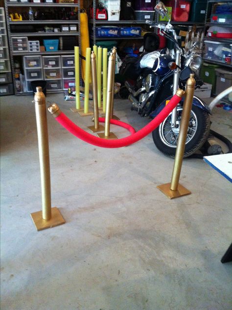 Homemade theater stanchions. Used a 6" square of plywood on bottom. Screw in a wooden dowel to the plywood and cover with a pool noodle. Cut the top off of a 16oz pop bottle for the top of the stand. Use the bottom of the pop bottle to attach to the red pool noodle to make the rope and attach a cup hook to hook it to the stand. Use an eyelet screw on the stand to attach the "rope" also put a wire through the red noodle so it could be bent and keep the swag shape. Job Fair Decorations, Hollywood Themed Party, Red Pool, Deco Cinema, Hollywood Birthday Parties, Party Game Ideas, Red Carpet Theme, Hollywood Birthday, Movie Night Birthday Party