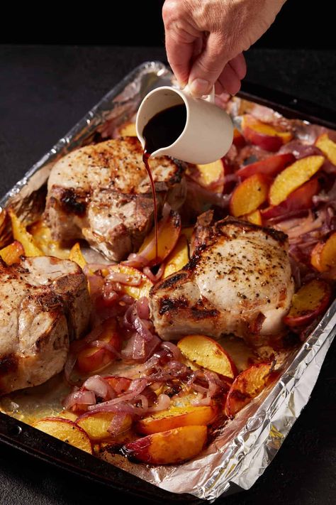 Pork chops and peaches on a sheet pan with balsamic vinegar being poured over the top. Pork Chops With Peaches, Curry Pork Chops, Oven Roasted Pork Chops, Maple Pork Chops, Roasted Peaches, Peach Pork Chops, Roast Pork Chops, Pork Roast In Oven, Tender Pork Chops