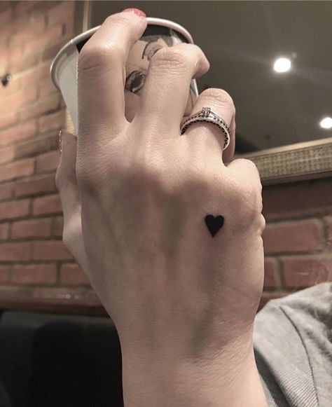 70 Lovely Heart Tattoo Designs And Their Meaning - The XO Factor Heart Tattoo Designs Small Finger, Edgy Heart Tattoo, Jet Black Heart Tattoo, Brown Heart Tattoo, Heart On Hand Tattoo, Small Black Heart Tattoo, Heart In Hand Tattoo, Love Hand Tattoo, Heart Tattoo Hand