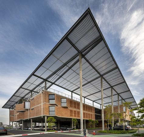 Aemulus is a 58,000 sf manufacturing & office building for an electronics company. The site overlooks the Penang airport runway which becomes the focus of the project & to which views are maximized. Conceptually, an elevated brick box separates to allow entry into a reception lobby overlooking the runway. The space between the two brick boxes, reception and circulation, becomes multi-functional over three levels. The predominantly brick façades to all but the open runway elevation have b Runway Design, Canopy Architecture, Main Entrance Door, Concrete Column, Architectural Competition, Steel Canopy, Roof Architecture, Canopy Design, Ground Floor Plan