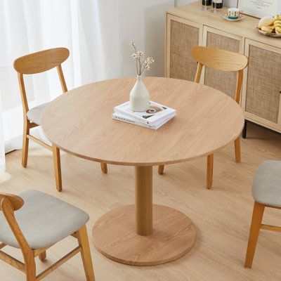 With its compact size and sculptural silhouette, this circular dining table is an ideal option for smaller kitchens and studio apartments. Its tabletop is made from engineered wood and rests on a pedestal base made from solid wood. The spacious table top measures 42'' in diameter, so it's ideal for seating up to four guests for a weeknight meal or a casual Sunday brunch. We love the way that this table’s distinctive design leaves plenty of legroom for you and your guests. Moreover, it comes with Round Wood Dining Table And Chairs, Dining Table Small Round, Mini Dining Table Small Spaces, Round Work Table, Round Wood Table Dining, Diy Round Dining Table, Circle Kitchen Table, Round Office Table, Dining Table Small Space