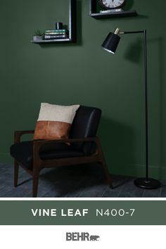 A dark green wall color, neutral black accents, and warm wood tones make for a stunning combination. BEHR® Paint in Vine Leaf forms the base of this sleek and sophisticated space. Click below for color details. Golf Bedroom, Green Wall Color, Behr Colors, Color Of The Month, Green Accent Walls, Dark Green Walls, Behr Paint Colors, Behr Paint, Green Paint Colors