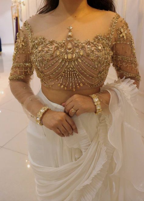 DELICATE CRYSTALS EMBELLISHED GOLD BLOUSE PAIRED WITH WHITE RUFFLE SAREE Embellished Gold Blouse For Reception, Embroidered Georgette Blouse Piece In Gold, Designer Gold Embellished Blouse, Luxury Gold Georgette Blouse, White Ruffle Saree, Gold Embellished Semi-stitched Blouse Piece, Crystal Blouse, Ruffle Saree, Gold Blouse