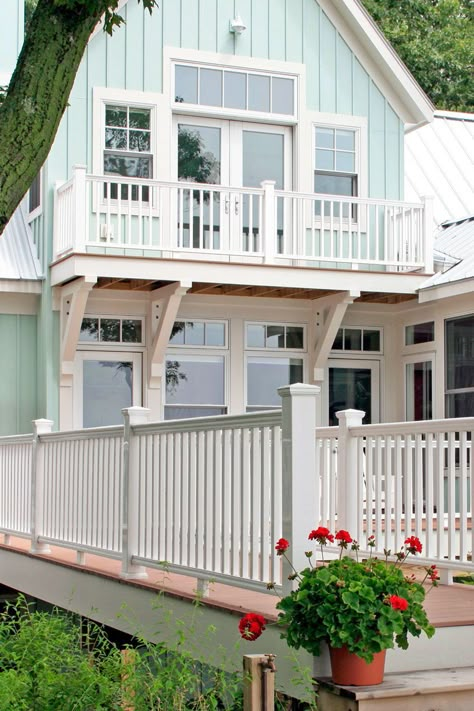 Seafoam green is an expected exterior paint color for a beach house surrounded by sand, but this stunning blue-green home is tucked away in the trees #exteriorpaintcolorsforhouse #homeremodel #colorschemes #bhg Seafoam Beach House Exterior, Modern Beach Houses Exteriors, Beach House Exterior Colors Florida Coastal Cottage, Aqua Blue Exterior House Colors, Pale Yellow Beach House Exterior, Aqua Beach House Exterior, Beach House Exterior Paint Colors Modern, Beachy Exterior Paint Colors For House, Exterior Paint Beach House