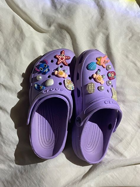 Purple crocs with charms #crocs #crocsoriginal #shoes #charms Dark Purple Crocs Outfit, Crocs Charm Ideas, Crocs Designer Jibbitz, Purple Crocs With Jibbitz, Crocks Shoes Purple, Jibbitz Crocs Charms, Croc Charms For Purple Crocs, Purple Custom Crocs, Light Purple Crocs With Charms