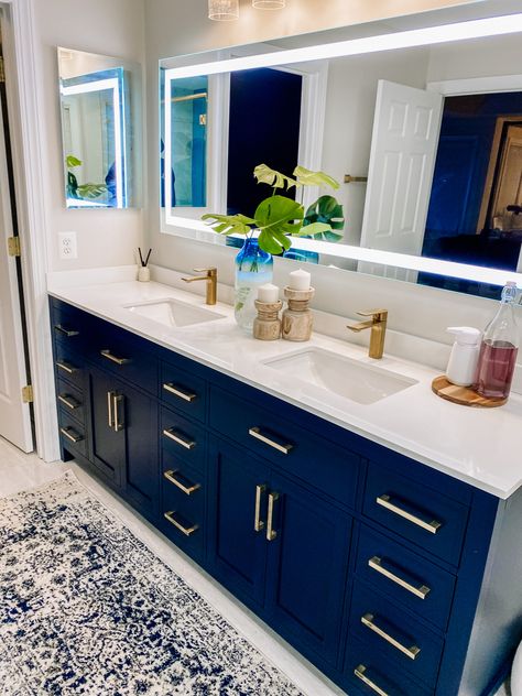 A bathroom vanity that is dark navy blue and has gold accents. This is a master bathroom Navy And Cream Bathroom, Cream Bathroom Decor, Blue Bathroom Accents, Navy Blue Bathroom Decor, Navy Paint Colors, Navy Bathroom Decor, Master Remodel, Navy Blue Bathrooms, Cream Bathroom