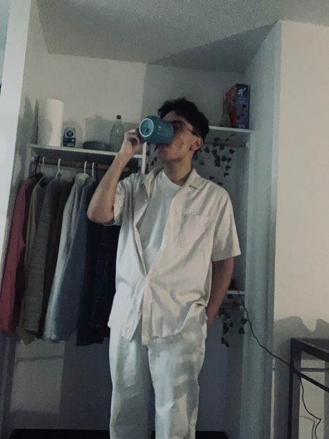 Man in all white, drinks coffee in front of closet. Drinking From Mug Reference, Holding Coffee Pose, Ironbark Lookout, Coffee At Night, Coffee Pose, Man Drinking Coffee, Coffee Night, Odd Names, Pose Practice