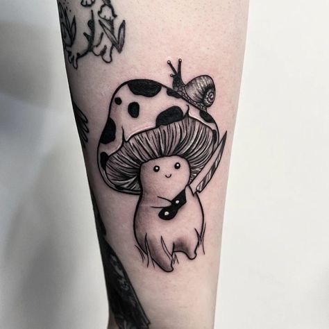 Black and grey tattoo of a mushroom man holding a little knife with both of his hands. There is a small snail on the top of the mushroom man's head on one side Evil Mushroom Tattoo, Goofy Mushroom Tattoo, Mushroom Tattoo Ideas For Men, Mushroom Knife Tattoo, Cute Animals Holding Knife Tattoo, Mushroom With Knife Tattoo, Lady With Mushroom Head Tattoo, Mushroom Holding A Knife Drawing, Cute Animal With Knife Tattoo