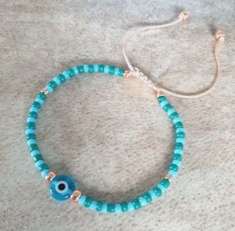 ▪︎☆Handmade ~ comes in a gift pouch ~ Free Postage ☆▪︎ Handmade adjustable bracelet or anklet made with small turquoise, teal and rose gold glass seed beads on nylon cord finished with an 8mm turquoise glass evil eye bead. I have used a stock photo, as all items are handmade, so the bracelet/anklet you receive will differ very slightly to the one in the photo. SIZING: Bracelet - approx 10 inches at its widest opening and 6 inches at its smallest.  Anklet - approx 12 inches at its widest opening and 8.5 inches at its smallest.  If you would like a different size please contact me. Teal And Rose Gold, Turquoise And Teal, Glass Evil Eye, Slider Bracelet, Turquoise Glass, Gift Pouch, Gold Glass, Adjustable Bracelet, Evil Eye