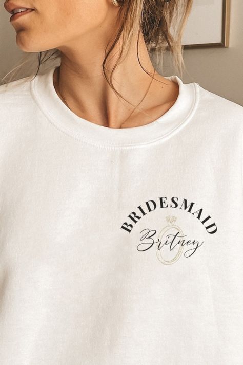 Make your bridesmaid proposal extra special with this personalized sweatshirt! It is a one-of-a-kind gift for your Maid of Honor that she will always remember. Perfect for the bachelorette party or as a surprise proposal, this custom hoodie will make a special addition to your bridal party. Featuring your bridesmaid's name, this stylish and comfy sweatshirt will be the perfect way to show how much you appreciate her!

#Bridesmaid#MaidOfHonor#Moh#BacheloretteParty#BridalShower #Bridesmaidgift Bridesmaid Apparel, Bridesmaid Sweaters, Bridal Party Merch, Bridesmaid Tshirt Ideas, Bridesmaid Shirt, Bridesmaid Hoodies Getting Ready, Bridesmaid Proposal Sweatshirt, Bridesmaid Sweatshirts Getting Ready, Maid Of Honor Sweatshirt