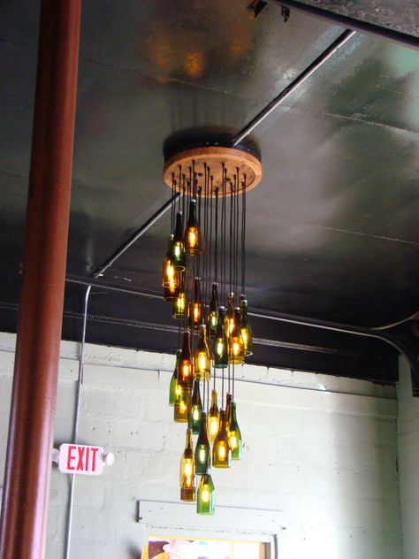 Looking for a great DIY home decor project? We’ve got a bright idea for you! Why not make a DIY wine or beer bottle chandelier. Most of us save our wine or beer bottles today to recycle, so its easy to put them aside for a craft project. Your family and friends will admire your … Beer Bottle Chandelier, Wine Bottle Chandelier, Bottle Chandelier, Luminaire Original, Recycled Wine Bottle, Diy Lampe, Recycled Glass Bottles, Wine Craft, Diy Chandelier