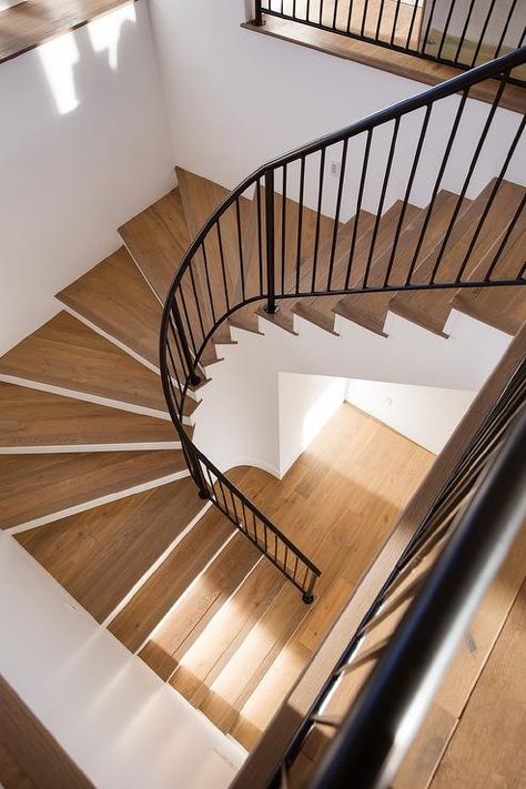 Wooden curved staircase boasts a wrought iron handrail. Cottage Staircase, Wooden Handrail, Wood Stair Treads, Modern Pool House, Wrought Iron Handrail, Wrought Iron Staircase, Staircase Runner, Wood Handrail, Iron Handrails