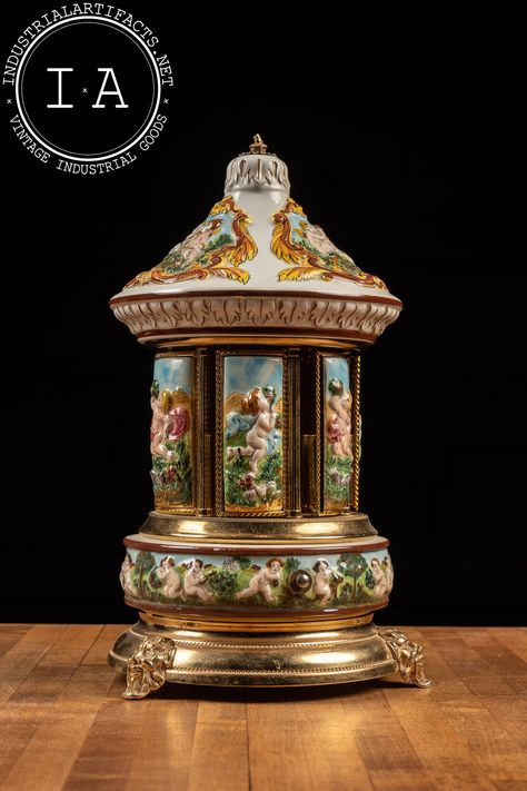 "Vintage Italian porcelain and Swiss movement music box carousel. This piece has pockets inside each of the door panels, typically used for cigarettes or lipstick. It features raised porcelain cherubs and gilt figural heads of the fertility deity Pan. The song that plays is \"Arrivederci Roma\" composed by Renato Rascel in 1955. The bronze or brass cherub finial on top has snapped off over time, but is still included with the piece. 7.5\" dia and 13\" H MM - 106401 - 062323 Please refer to photo American Literature Books, Music Box Ballerina, Music Box Vintage, Music Boxes, Door Panels, Crochet For Boys, Orange Art, Vintage Beauty, Vintage Italian