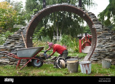 Download this stock image: Perm, Russia - September 01, 2020: worker builds a round entrance called a moon gate in a Chinese-style garden - 2DN60J0 from Alamy's library of millions of high resolution stock photos, illustrations and vectors. How To Build A Moon Gate, Moon Gate Diy, Portal Garden, Round Doorway, Perm Russia, Moon Gates, Moon Arch, Landscape Hardscape, Yard Gate