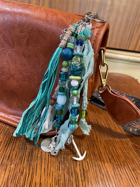 Introducing our Boho Purse Tassel - a handcrafted accessory that embodies the essence of bohemian beauty. Its lush threads, adorned with beads, and accessories, effortlessly complement any boho-inspired look. Attach it to your handbag or keychain for a touch of wanderlust and individuality, and elevate your fashion game with this enchanting accessory. Boho Tassel Keychain, Boho Style Purses, Boho Bag Charm, Purse Charms Diy, Boot Charms, Tassel Crafts, Hat Jewelry, Bohemian Beauty, Keychain Craft