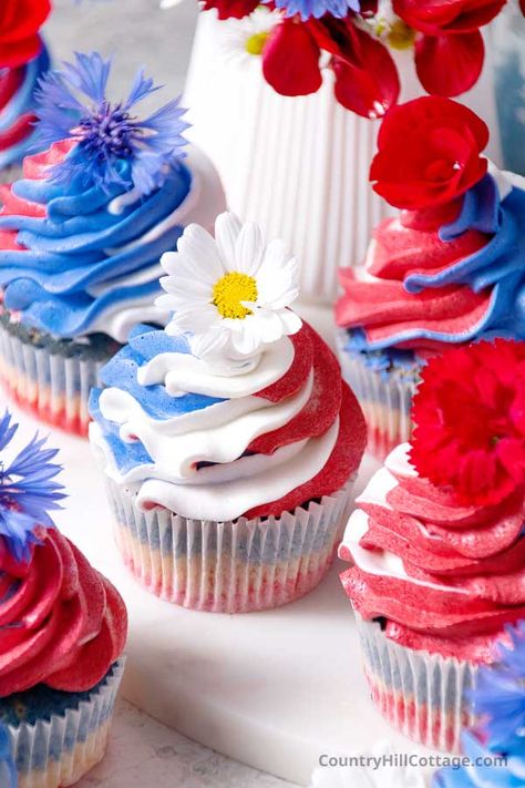 These easy 4th of July cupcakes recipe are a delicious way to celebrate Independence Day, Memorial Day and other patriotic holidays. These light and fluffy cupcakes are decorated with red white and blue buttercream swirls to reflect the colors of the American flag. Edible flower toppers are a cute and simple idea to decorate these red white and blue cupcakes. They are 4th of July dessert for a crowd and are great for parties, gatherings, and barbecues. | CountryHillCottage.com Red White And Blue Cupcakes, White And Blue Cupcakes, Dessert For A Crowd, 4th Of July Cupcakes, Memorial Day Desserts, 4th Of July Dessert, Patriotic Cupcakes, Fluffy Cupcakes, Red Cupcakes