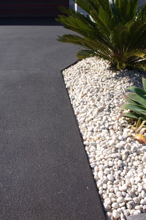 This image shows a concrete driveway coloured Jet Black with a Dulux Avista Colour Hardener. The dramatic tone creates a stunning contrast against the white pebbles in the garden bed. Colored Concrete Patio, Pebble Driveway, Driveway Paint, Cement Driveway, Front Garden Ideas Driveway, Poured Concrete Patio, Concrete Pathway, Concrete Backyard, Modern Driveway