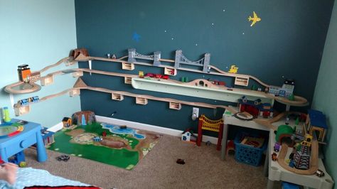 Train track wall,  used balsa wood for the train tracks to run along.  Then i used $1 craft crates from Michaels to hold it up.  Attached an a spray painted record to a standard shelf bracket to allow the track room to turn around at the ends.  I also incorporated a shelf we already had in the room... Diy Train Tracks On Wall, Train Play Ideas, Wooden Train Track Storage, Wall Train Track, Train Around Room, Thomas The Train Room Ideas, Wall Track For Cars, Wall Mounted Car Track, Car Track On Wall