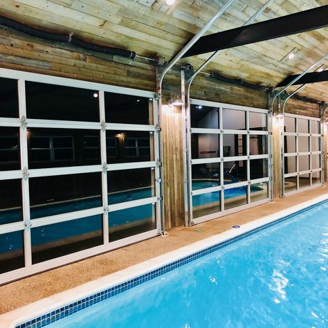 Indoor pool with glass garage doors Indoor Pool With Garage Doors, House Plans With Indoor Pool, Pool In Garage, Pool Enclosure Ideas, Indoor Pool Ideas, Barn Pool, Small Indoor Pool, Indoor Pool House, Indoor Pools