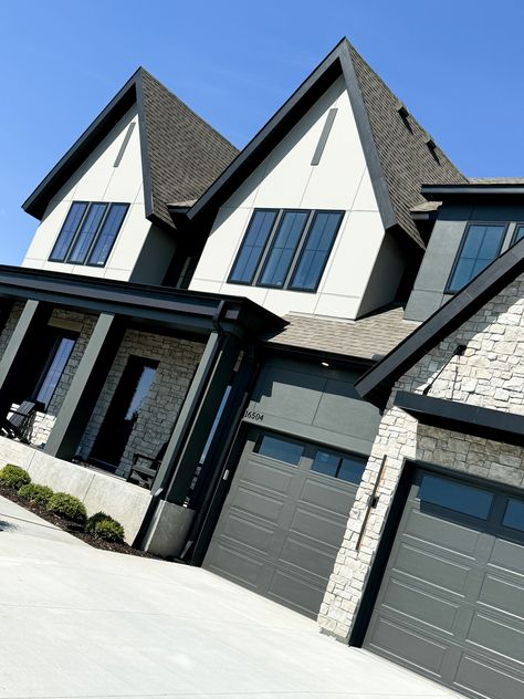 We continue to see black and white exteriors in many of the new construction homes featured in the 2024 Fall Parade of Homes! This particular example is stunning how it also pairs a more organic style stone to the front entryway and garage, giving it amazing curb appeal!!   New Construction | Home Trends 2024 | Home Design | Minnesota Home Trends White And Black Craftsman Exterior, Black And White Exterior House, Black White Exterior, White Exterior Houses, Exterior Inspiration, Minnesota Home, Craftsman Exterior, Front Entryway, Construction Home