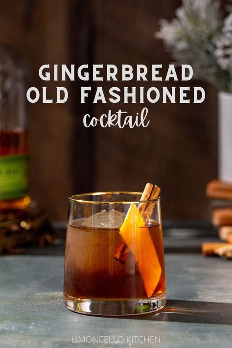 Gingerbread Old Fashioned cocktail in an old fashioned style glass. The drink is brown and has a large sphere of ice in the glass along with an orange peel and a cinnamon stick garnish. In the background to the left is a bottle of Bulleit rye whiskey, and to the right is a vase with snowy looking evergreens with a stack of wooden coasters under the vase. Text overlay above the cocktail reads “Gingerbread Old Fashioned cocktail”. Cinnamon Holiday Cocktails, Gingerbread Bourbon Cocktail, Ginger Old Fashioned Cocktail, Ginger Bread Cocktail, Gingerbread Whiskey Cocktail, Gingerbread Cocktail Holiday Drinks, Pendleton Whiskey Drinks, Gingerbread Old Fashioned, Winter Whiskey Drinks