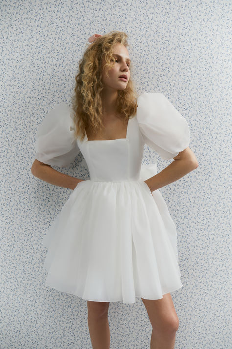 Stylish short wedding dress featuring puffed sleeves, a large back bow, and a lace-up corset. Made from high-quality organza, the Maria Dress is lightweight and airy, perfect for dancing the night away. The skirt is designed to be voluminous yet delicate, creating a dreamy and ethereal effect as it moves with you. 
Material: Organza; Size Guide: 0-28

#elopementdress #receptiondress #secondweddingdress #shortweddingdress  #bridetobe2024 #bridetobe2025 #bridalshowerdress #rehearsaldinnerdress Wedding Dress Elopement, Dress Organza, Courthouse Wedding Dress, Midi Wedding Dress, Dress Engagement, Bachelorette Party Dress, Spring Wedding Dress, Rehearsal Dinner Dresses, Engagement Dress