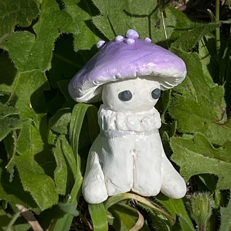 A cute little handmade clay purple mushroom in the grass Small Clay Sculptures Aesthetic, Clay Mushrooms Aesthetic, Mushroom Clay Art, Clay Art Ideas Mushroom, Clay Mushroom People, Mushroom Clay Sculpture, Diy Mushrooms, Mushroom Guy, Mushroom Clay