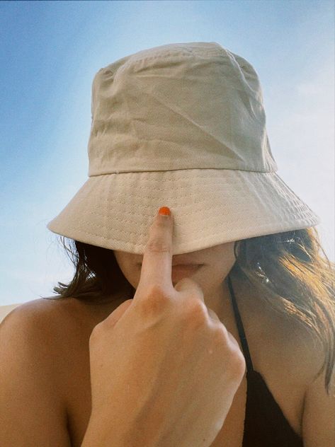 The girl is wearing a bucket hat and she took a selfie covering her face and her index finger is pulling down the bucket hat on her face. Bucket Hat Photoshoot Ideas, Bucket Hat Poses, Outing Pics, Bucket Hat Summer Outfit, Bucket Hat Photoshoot, Bucket Hat Beach Outfit, Punta Cana Pictures, Photo Inspiration Beach, Hat Photoshoot