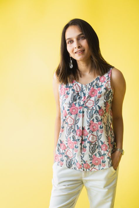 The angelic white of Meeram is splattered with beautiful floral motifs in beautiful hues of pink. The chic buttoned top is made out of 100% premium cotton. The sleeveless number looks stunning when paired with our ultra-comfortable cotton pants in white. Cotton Short Tops Sleeveless, Cotton Sleeveless Top, Cotton Top Ideas For Women, Sleeveless Short Kurti Designs, Sleeveless Short Kurti, Cotton Tops Designs For Jeans, Cotton Tops For Jeans, Kurta Designs Women Casual, Cotton Tops For Women