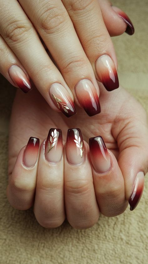 Transform your manicure game with this stunning burgundy ombre design on a chic beige base! The smooth gradient creates a rich, sophisticated look, while delicate gold floral accents add a touch of glamour and charm. Perfect for any occasion, these nails effortlessly blend elegance and creativity. Whether you’re heading to a special event or just want to elevate your everyday style, this nail art is sure to turn heads. #acrylicnails #septembernails #nailsdesign #fallnails Dark Ombre Nail Designs, Ombre Thanksgiving Nails, Maroon Ombre Nails Burgundy, Fall Wedding Nails For Bride Burgundy, Ombre Autumn Nails, Burgundy Nails With Gold Glitter, Floral Fall Nails, Maroon Ombre Nails, Burgundy Ombre Nails