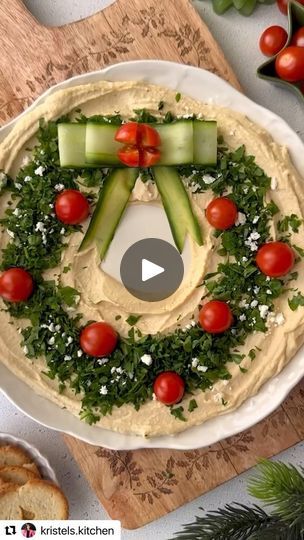 4K views · 239 reactions | Quick, easy and affordable 👏👏👏 
Solution: Add pesto to the hummus if you want it to be green like a wreath. Thinly slice a French bread baguette, and slightly toast in oven 425 for 10 minutes. 
Check out @kristels.kitchen for more great holiday ideas. 
・・・
1- Place a small bowl in the middle of your serving plate and evenly spread the hummus all around.
2- Remove the small bowl and top the hummus with chopped parsley, cherry tomatoes and feta.
3- Using a vegetable peeler, peel a few cucumber strips, form a Christmas ribbon as shown in the reel and place on top of the hummus. 
4- Serve with crackers or toasted bread. Enjoy!✨ 

#hummus #christmasfood #festivevibes #funfood #holidayfun #partyideas | Sami Small | Quick Solutions for Simplifying Your Life Hummus Appetizers, Xmas Appetizers, Tomatoes And Feta, Toasted Bread, Cook Recipes, Xmas Food, Buffet Food, Vegetable Peeler, Christmas Cooking