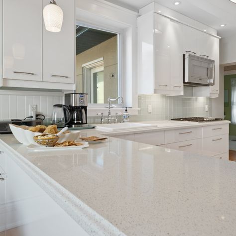 While white quartz creates a designer look in any kitchen and gives off the look and advantages of a luxury, premium product, the prices are not high. #quartzcountertops #quartz #quartzkitchen #kitchendesign #kitchenremodel #kitchenbacksplash #kitchenisland #kitchencountertops #countertops #whitekitchen #whitequartz #whitequartzkitchens #whitequartzcountertops #neutralhome #kitchenrenovation #kitchengoals #whitequartzcounters #modernfarmhouse #coastalkitchen #whitecabinets Quartz Countertop And Tile Backsplash, Iced White Quartz Countertop Kitchen, White Sparkle Quartz Countertop Kitchen, Snow White Quartz Countertop Kitchen, Sparkling White Quartz Countertop With Backsplash, Blanco City Quartz Countertops, Frost White Quartz Countertop, White Sand Quartz Countertop, Sparkle Quartz Countertop