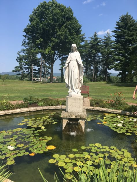 Lily Pond & Statue of Our Lady at St.Mary’s University of Minnesota Virgin Mary Statue Garden Ideas, Statue In Garden, Marian Garden Catholic, Mary Statue Garden, Garden Virgin Mary, Mother Mary Statue Garden, Mary Garden Statue, Grotto For Mary Statue, Virgin Mary Statue Garden