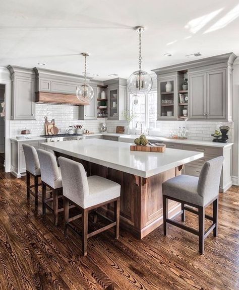 a modern farmhouse kitchen with a large kitchen island of wood and a white ston countertop that doubles as a dining table Remodel Pantry, Kitchen Chandeliers, Kitchen Design Countertops, 1960s Kitchen, Best Kitchen Countertops, 1970s Kitchen, �Серая Кухня, Affordable Kitchen, Grey Kitchen Designs