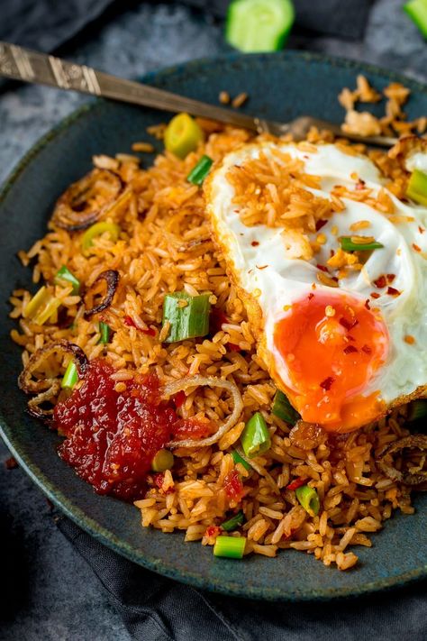 Nasi Goreng is a delicious spicy stir-fried rice. It's more flavourful than regular fried rice with the addition of shrimp paste, fish sauce, tamarind and a few other goodies. Topped with a runny fried egg (those crispy edges are a must!), this classic Asian meal makes a great family dinner. When you're in the mood for street food at home, this is the one to go for. #nasigoreng #Indonesianfood Nasi Goreng Recept, Nasi Goreng Recipe, Tasty Fried Rice, Chinese Fried Rice, Beef Fried Rice, Healty Dinner, Spicy Rice, Rice Bowls Recipes, Diner Recept