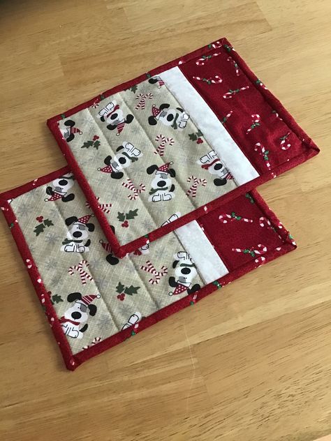 How cute are these little puppies in their Christmas hats!  The reverse side is black with paw prints and puppy treats.  Set of two mug rugs.  They measure about 9 1/2"x7 1/2".  Quilted using Warm and White Batting.  Binding is machine sewn to the front and hand stitched to the back.  Washable.  Do not use bleach.  Machine dry and touch up with warm iron if necessary.   Handmade in my smoke-free, pet-free home using quilt shop quality fabrics. Ready to ship. Christmas Mug Rugs Patterns Free, Mug Rugs Patterns Free, Rug Mugs, Quilted Mug Rugs, Christmas Mug Rugs, Table Topper Patterns, Mug Rug Patterns, Christmas Hats, Christmas Skirt