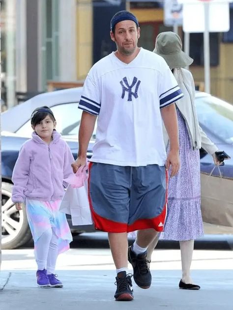 Adam Sandler always looks comfortable in basketball shorts and baggy tees (it’s his staple look), but he's been seen in other bizarre outfits over the years. Let’s see some of Adam Sander’s most iconic outfits. Adam Sandler Paparazzi, Adam Sanders Outfits, Adam Sandler Street Style, Sandler Family, Adam Sandler Outfits Spirit Week, Adam Sandler Outfits, Adam Sanders, Finally Getting Married, Dad Fits